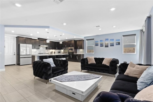 living room with light tile patterned flooring, visible vents, and recessed lighting