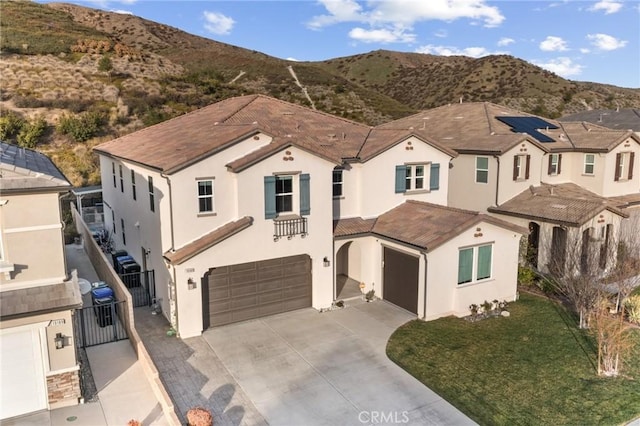 mediterranean / spanish-style home featuring driveway, an attached garage, a gate, fence, and a mountain view