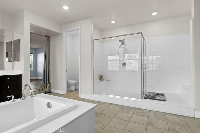 bathroom featuring toilet, a stall shower, vanity, tile patterned flooring, and a bath