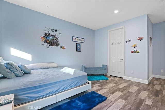 bedroom with recessed lighting, baseboards, and wood finished floors