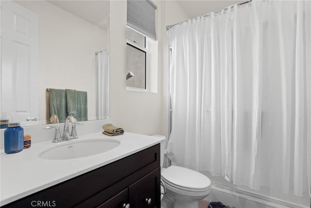 bathroom with curtained shower, vanity, and toilet