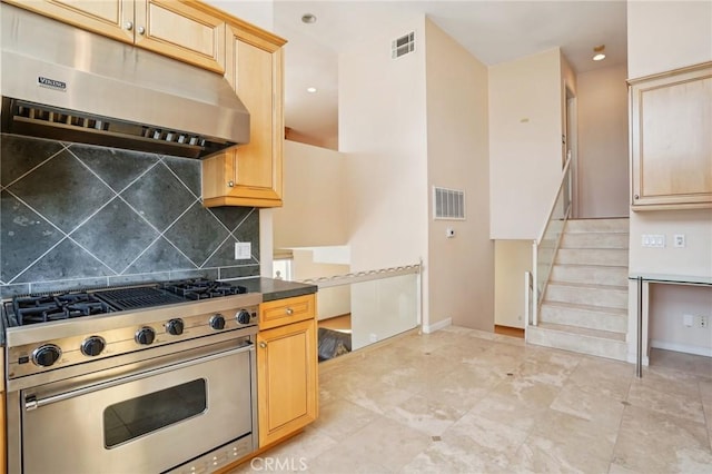 kitchen featuring visible vents, high end stainless steel range oven, backsplash, light brown cabinets, and under cabinet range hood