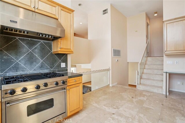 kitchen featuring tasteful backsplash, visible vents, light brown cabinets, under cabinet range hood, and stainless steel stove