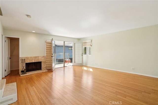 unfurnished living room featuring recessed lighting, baseboards, light wood finished floors, and a fireplace