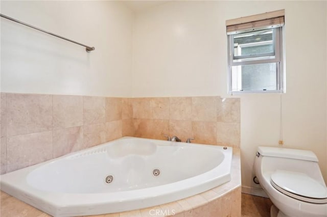 bathroom featuring a tub with jets and toilet