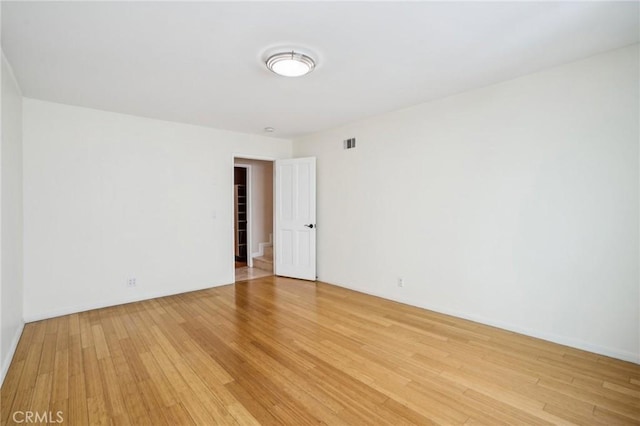 spare room featuring visible vents and light wood-style flooring