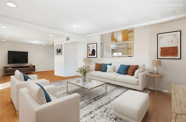living area with wood finished floors, visible vents, and recessed lighting