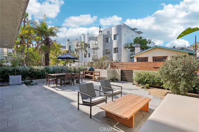 view of patio / terrace featuring fence, a residential view, and outdoor dining space