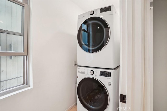 clothes washing area featuring laundry area and stacked washing maching and dryer