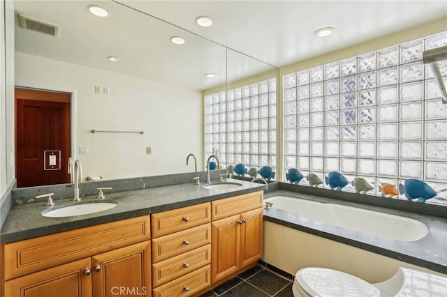 bathroom featuring tile patterned flooring, visible vents, a sink, and a bath