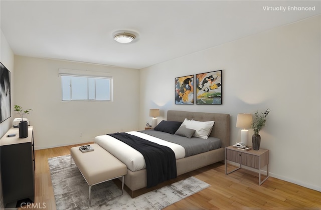 bedroom with light wood finished floors and baseboards