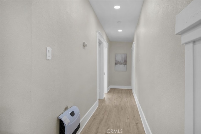 corridor with recessed lighting, heating unit, light wood-style flooring, and baseboards