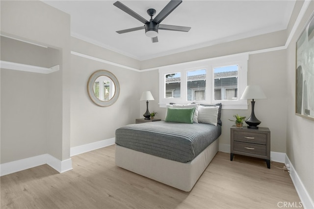 bedroom with ceiling fan, ornamental molding, light wood-style flooring, and baseboards