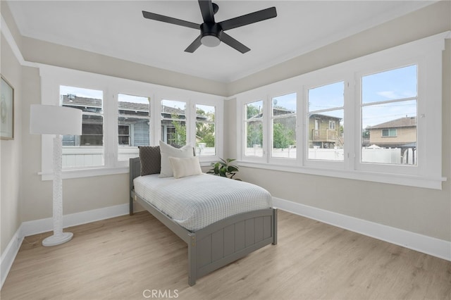 bedroom featuring light wood-style flooring, baseboards, and a ceiling fan