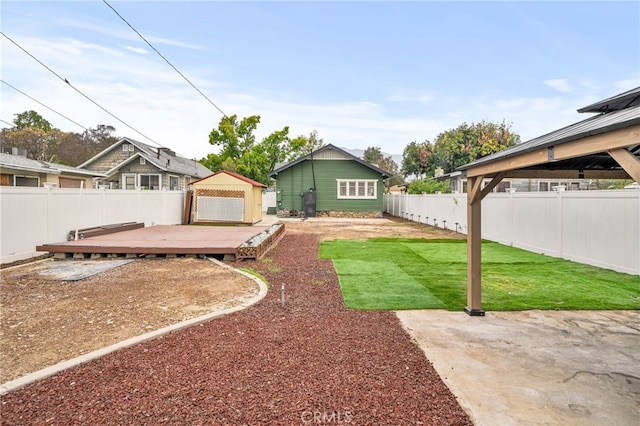 view of yard with a fenced backyard, a deck, and a gazebo