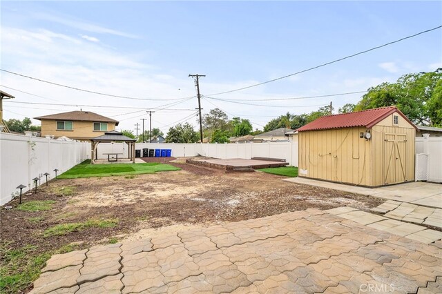 view of yard with a patio area, a shed, a fenced backyard, and a gazebo