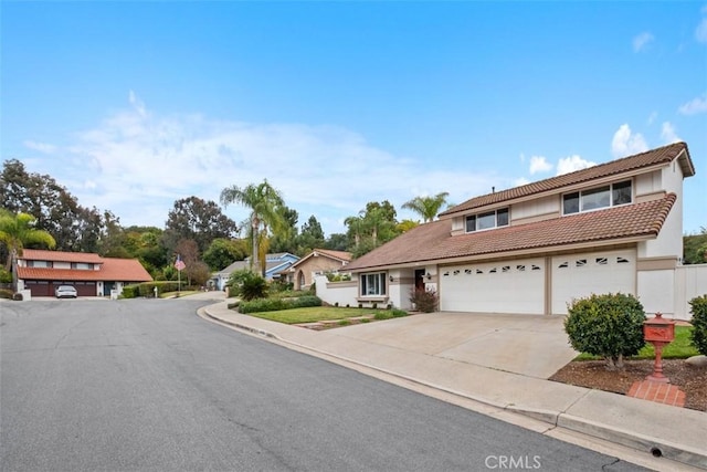 view of front facade with concrete driveway, an attached garage, a tile roof, and stucco siding