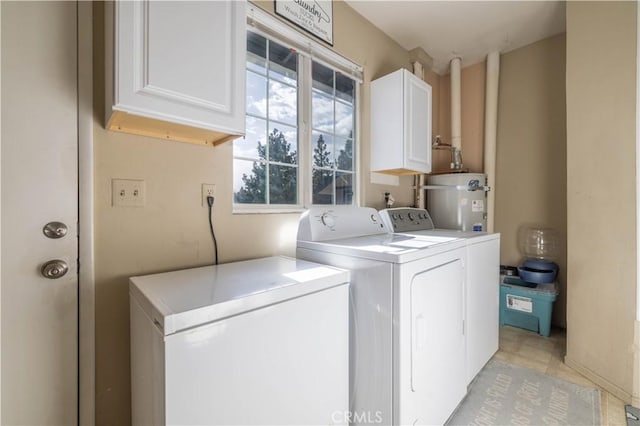 laundry area with cabinet space, washing machine and dryer, and water heater