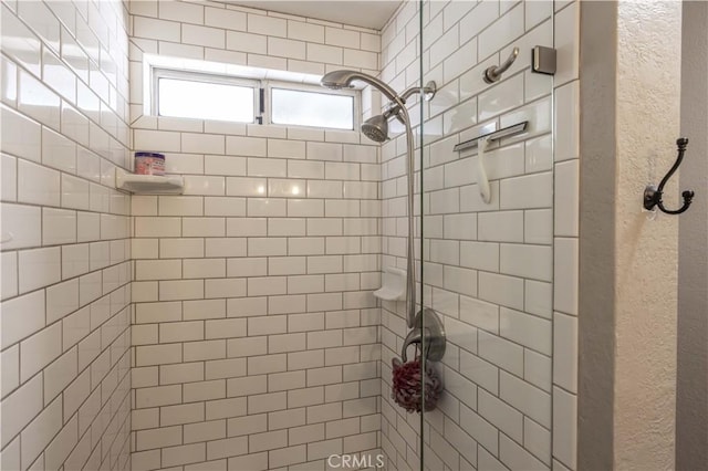 bathroom featuring a textured wall and a shower stall