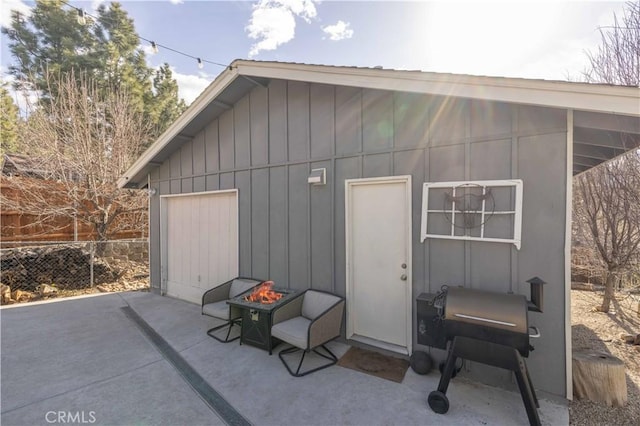 view of outdoor structure featuring an outdoor fire pit and fence