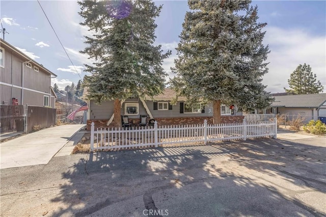 view of front of home featuring concrete driveway and a fenced front yard