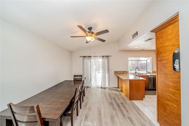 dining area with vaulted ceiling, ceiling fan, light wood-type flooring, and visible vents