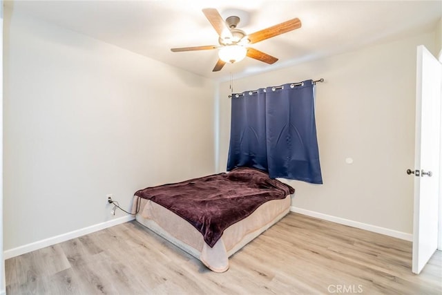 bedroom featuring light wood-style flooring, baseboards, and a ceiling fan