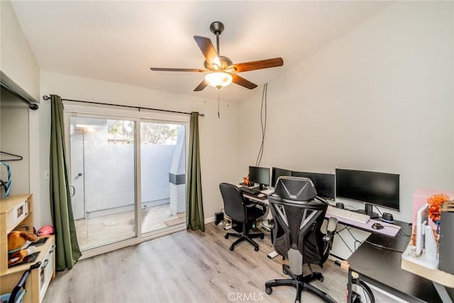 office space with baseboards, a ceiling fan, and light wood-style floors