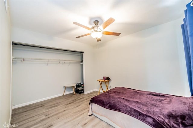 bedroom with ceiling fan, light wood finished floors, a closet, and baseboards