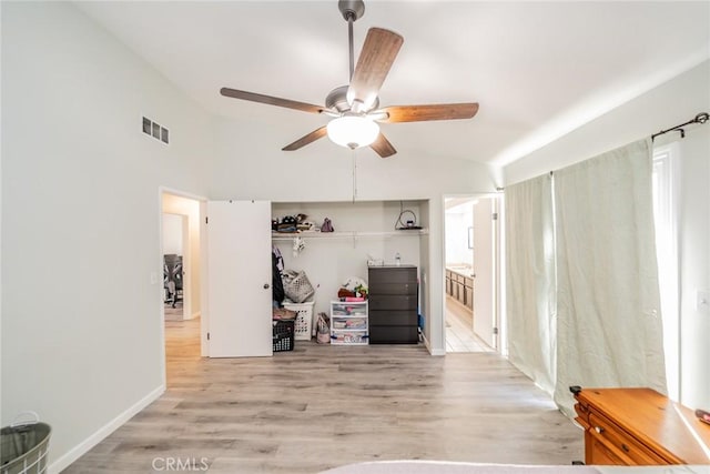 interior space with light wood-style floors, lofted ceiling, visible vents, and a ceiling fan