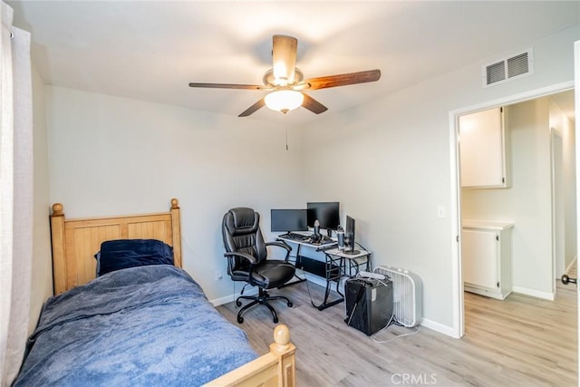 bedroom with ceiling fan, light wood finished floors, visible vents, and baseboards