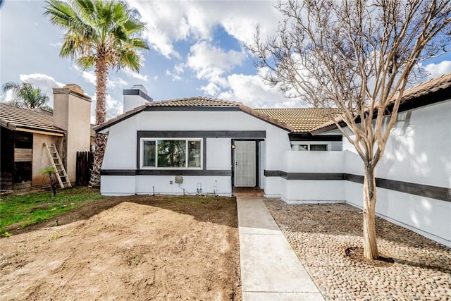 view of front of house with a tiled roof and stucco siding