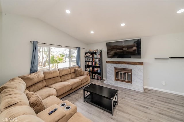 living area featuring baseboards, wood finished floors, vaulted ceiling, a fireplace, and recessed lighting