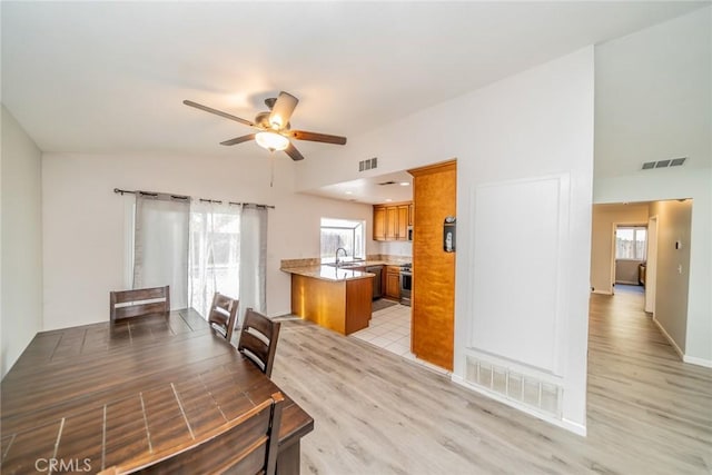 dining room featuring light wood-style floors, visible vents, and a ceiling fan