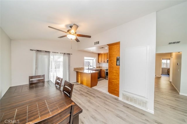 dining space with light wood-style floors, visible vents, and ceiling fan