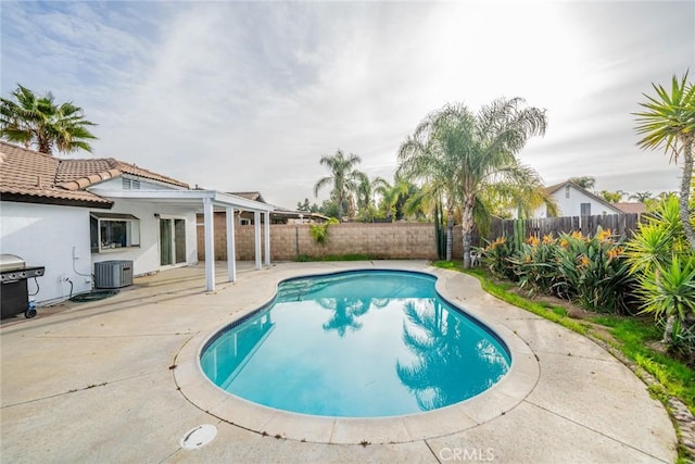view of pool featuring a grill, a fenced backyard, a patio, a fenced in pool, and central AC unit