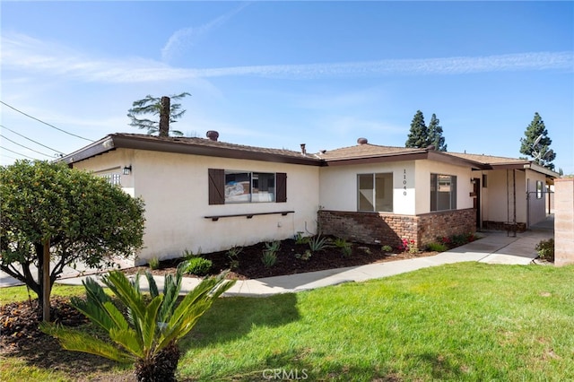 single story home with a front lawn, brick siding, and stucco siding