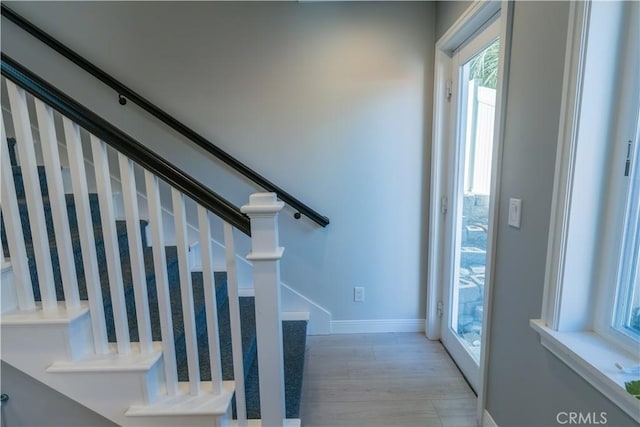 stairs featuring wood finished floors and baseboards