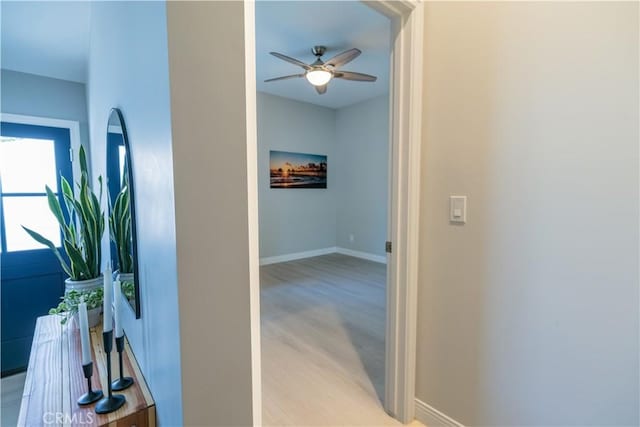 hallway featuring light wood-type flooring and baseboards