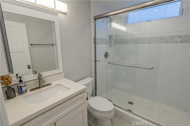 full bath featuring vanity, a shower stall, and toilet