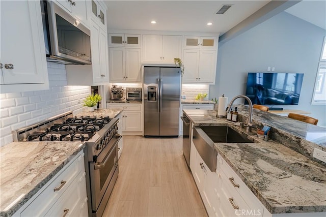 kitchen featuring stainless steel appliances, visible vents, a sink, and white cabinetry