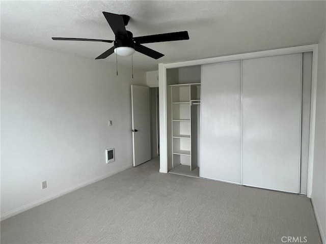 unfurnished bedroom with carpet, a textured ceiling, a ceiling fan, and a closet