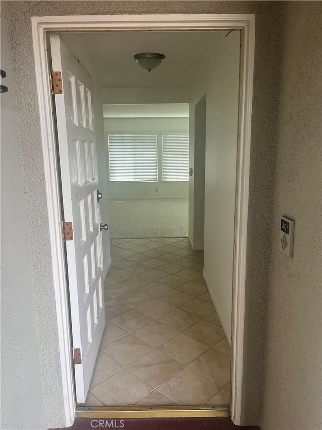 hall with light tile patterned floors