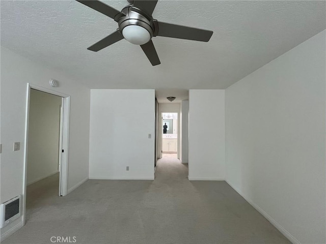 unfurnished room featuring baseboards, a textured ceiling, visible vents, and carpet flooring