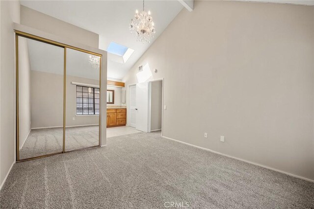 unfurnished bedroom featuring a skylight, beam ceiling, a chandelier, light carpet, and high vaulted ceiling