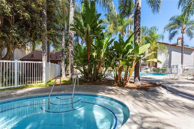 pool with a patio area and fence