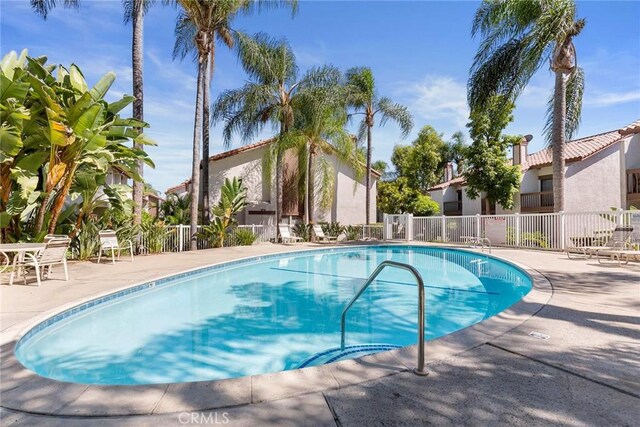 community pool featuring a patio area and fence