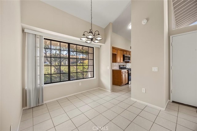 unfurnished dining area with light tile patterned floors, high vaulted ceiling, baseboards, and an inviting chandelier