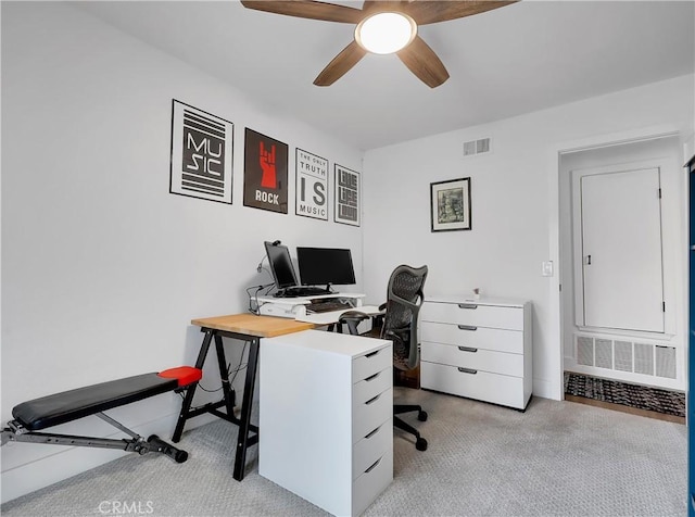 carpeted office space featuring visible vents and ceiling fan