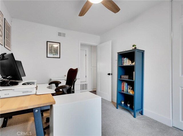 office with ceiling fan, visible vents, baseboards, and light colored carpet